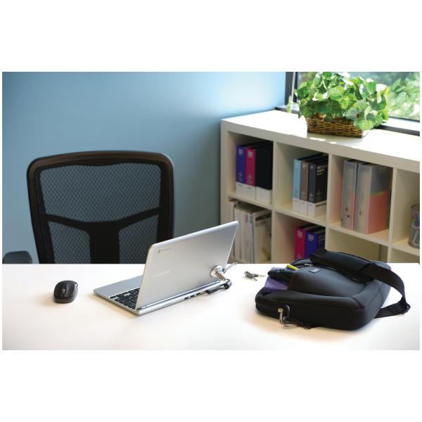 Silver laptop on office desk with black mouse, bag, and bookshelf background