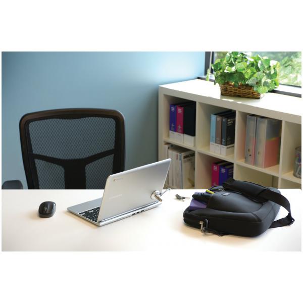 Silver laptop on desk with mouse, black bag, and bookshelf in office setting