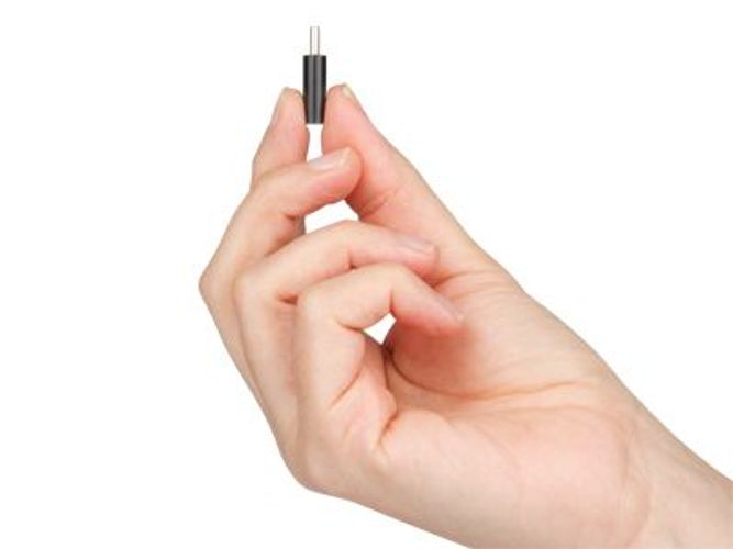 Hand holding small black IT connector plug, ideal for hardware upgrades and repairs